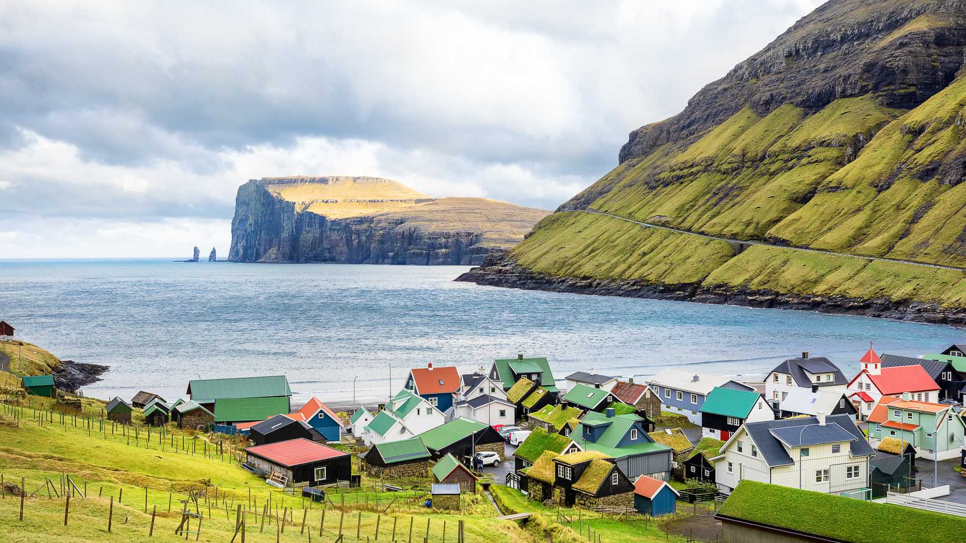 Maisons colorées du village de Tjørnuvík avec les falaises spectaculaires et les cheminées de mer, Risin et Kellingin, Îles Féroé.