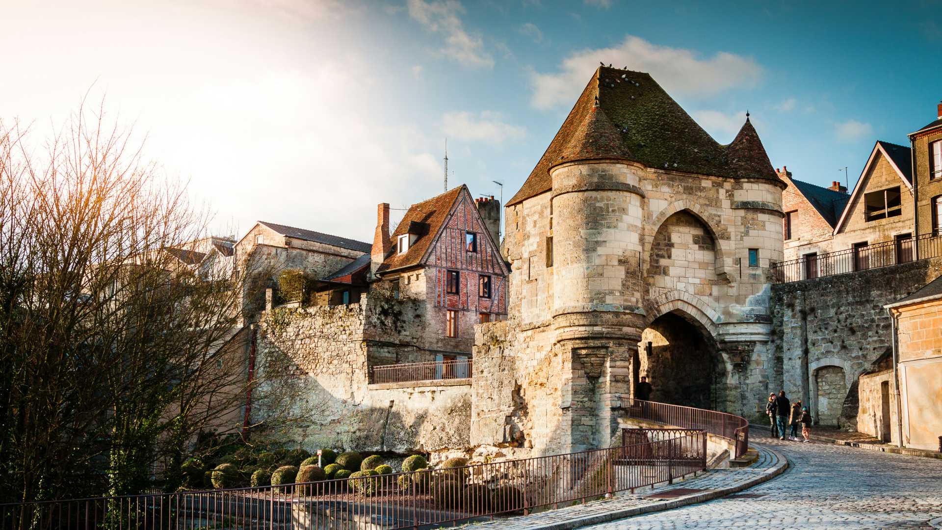 La Porte d’Ardon in Laon, a medieval gate with stone walls and turret, under a sunny sky.