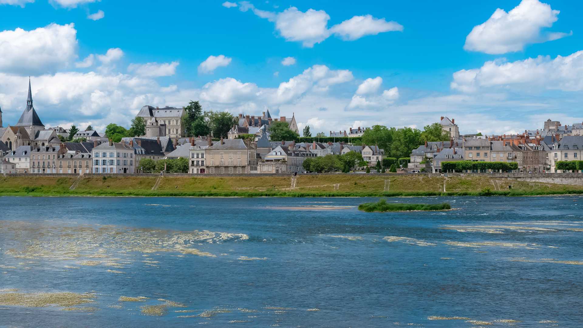 Panorámica de la ciudad de Blois con la iglesia de Saint-Nicolas y el río Loira, mostrando su arquitectura histórica y sus hitos culturales