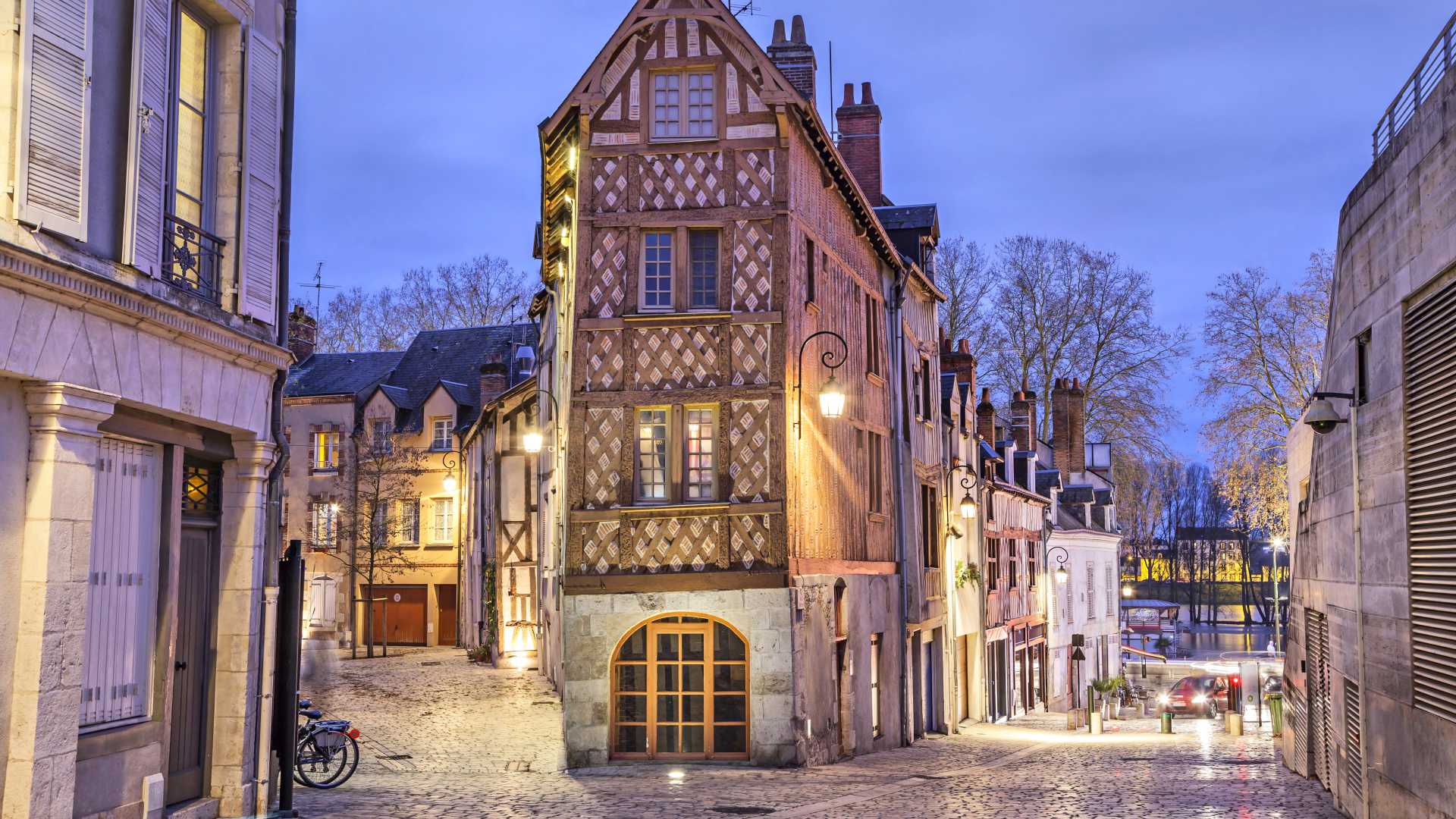 Charmantes Fachwerkhaus an einer Kopfsteinpflasterstraße in der Abenddämmerung im Herzen von Orléans, Frankreich.