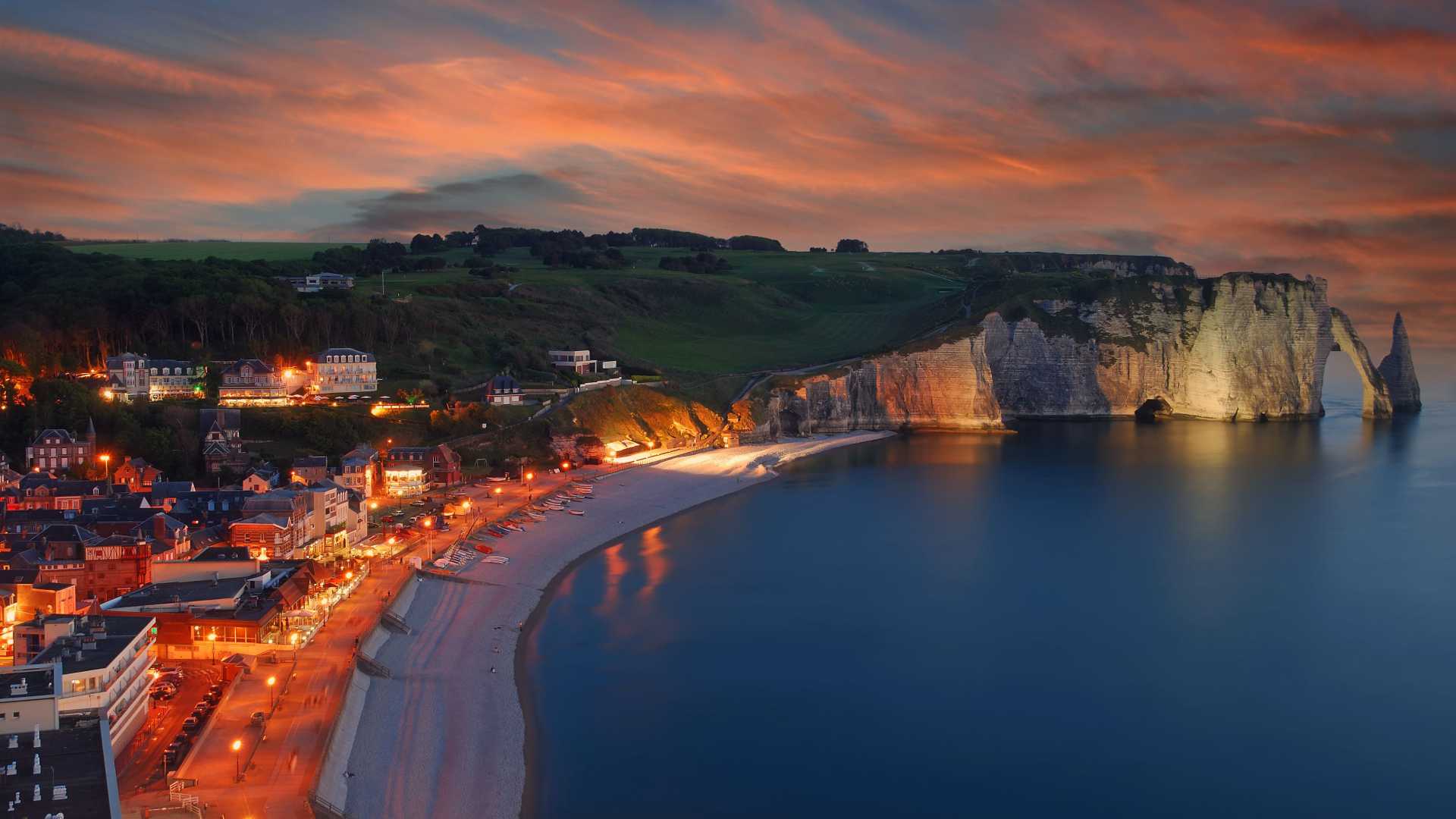 Vista notturna del villaggio di Etretat con le scogliere di gesso sulla costa e il tranquillo Mare del Nord