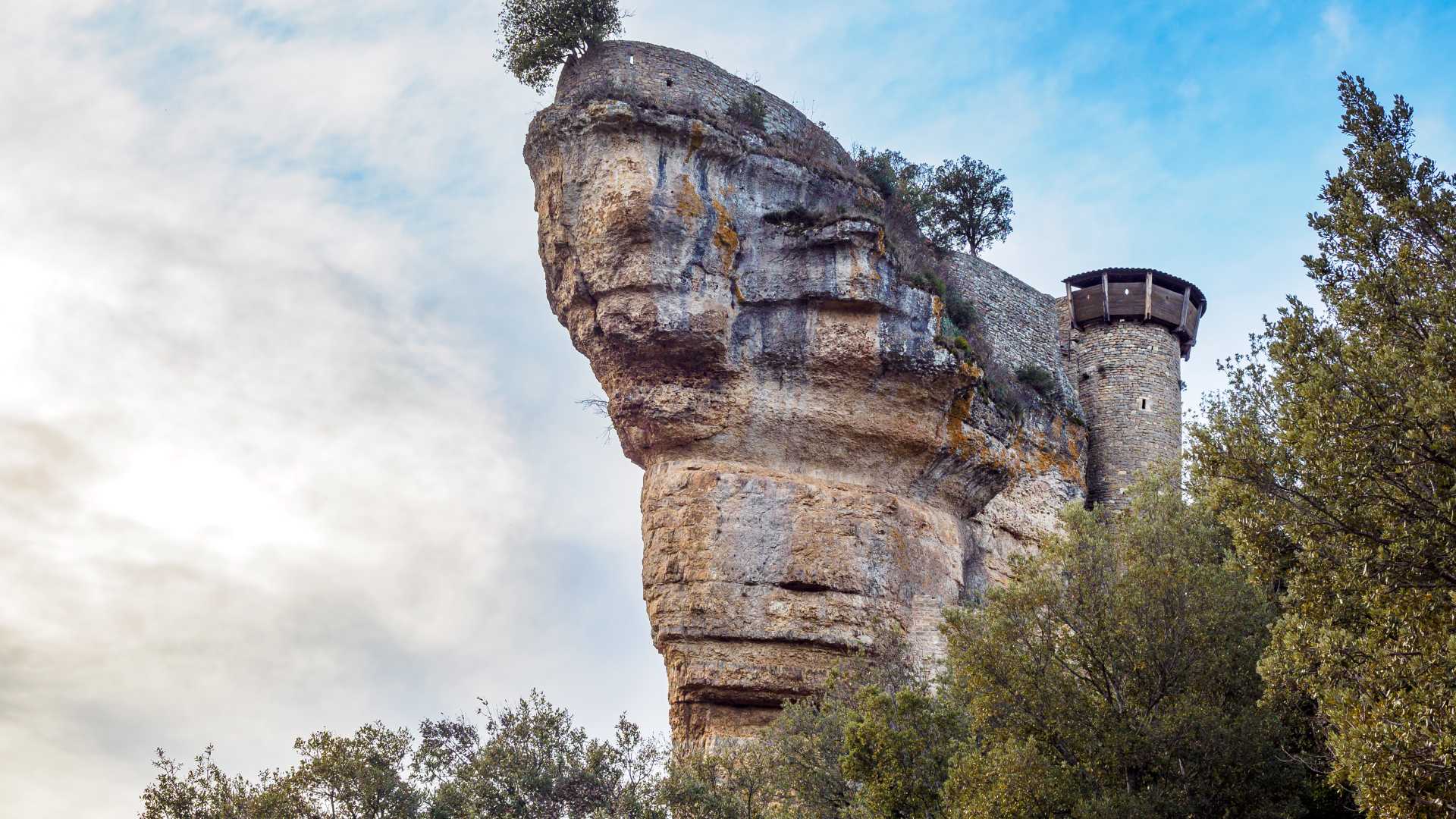 The ancient Peyrelade Castle perched on a dramatic rock formation in Cevennes National Park, France.