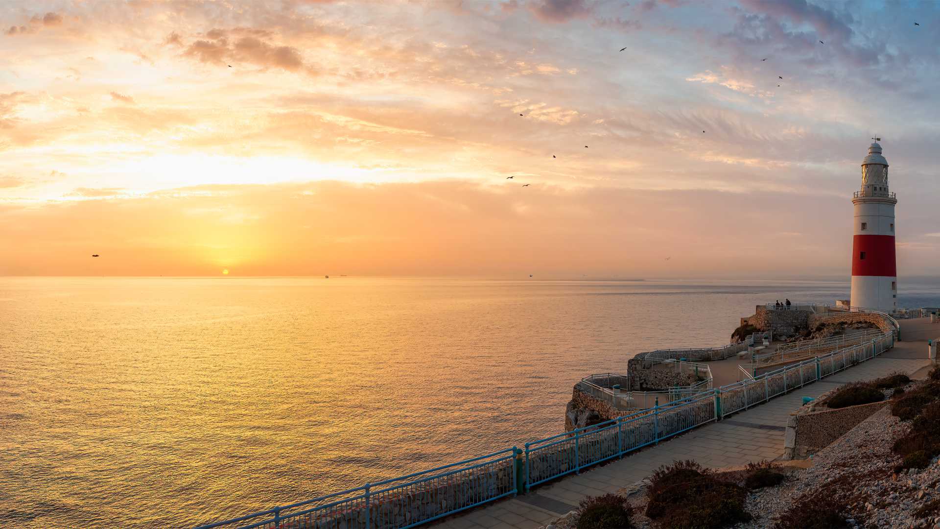 Der Leuchtturm von Europa Point bei Sonnenaufgang, bei strahlendem Himmel und ruhiger See in Gibraltar.