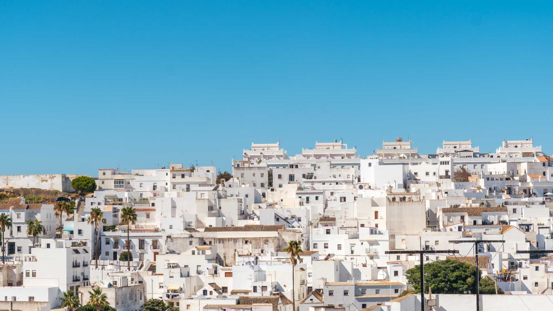 Whitewashed houses of Vejer de la Frontera, Andalusia, under a clear blue sky.