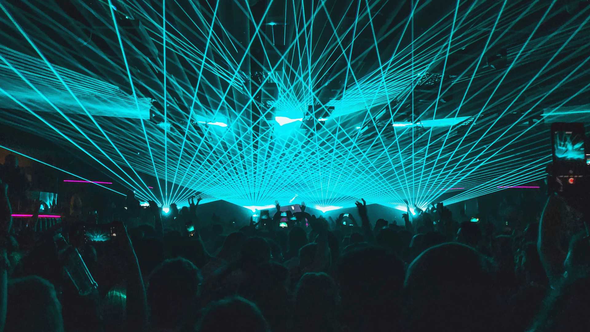 Une boîte de nuit vibrante à Ibiza avec des lumières laser bleues éblouissantes et une foule énergique.