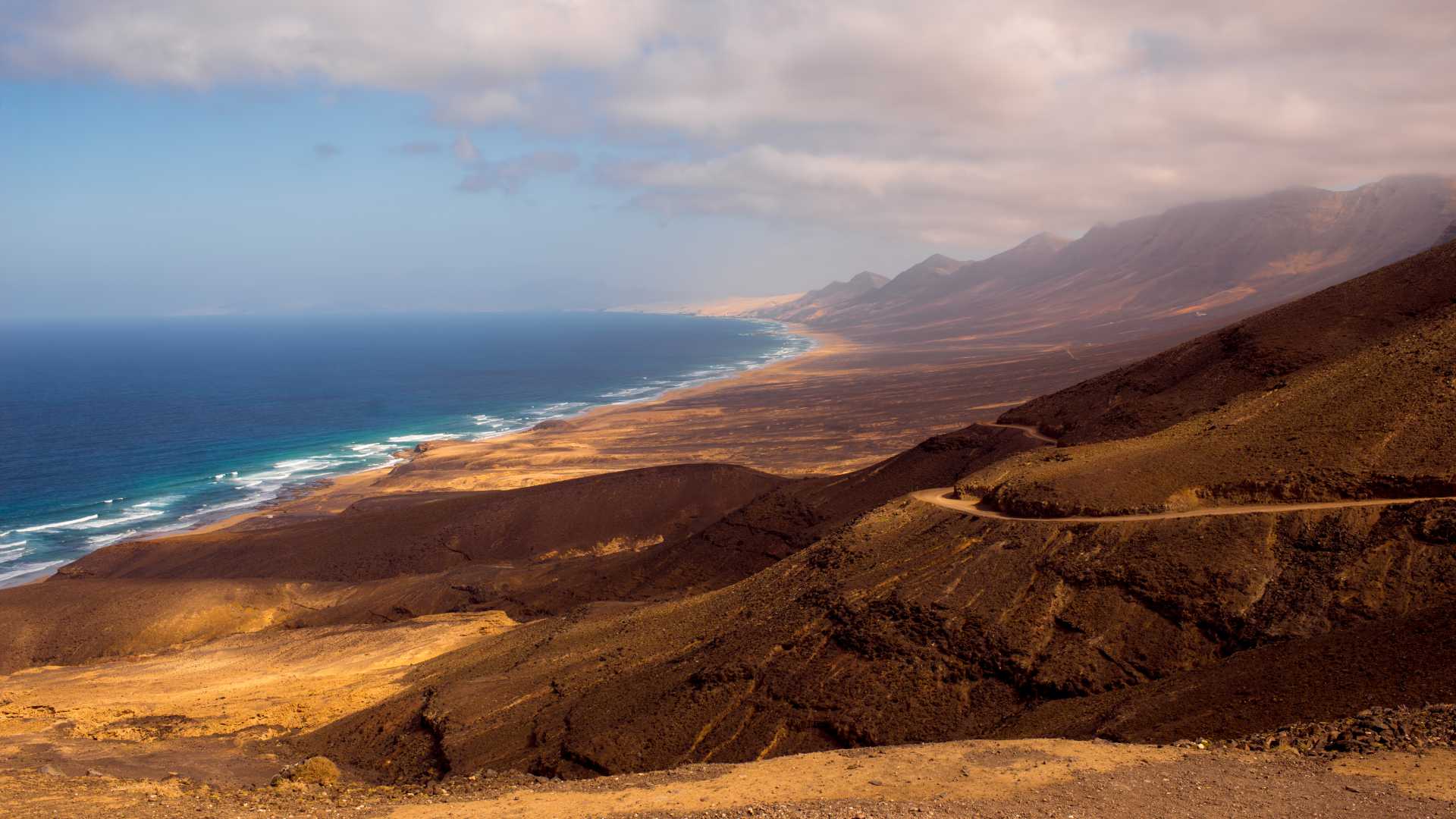 Impresionante vista superior de la extensa costa de Cofete, mostrando la playa, los acantilados y el océano azul, ideal para explorar, viajar y pasar las vacaciones.