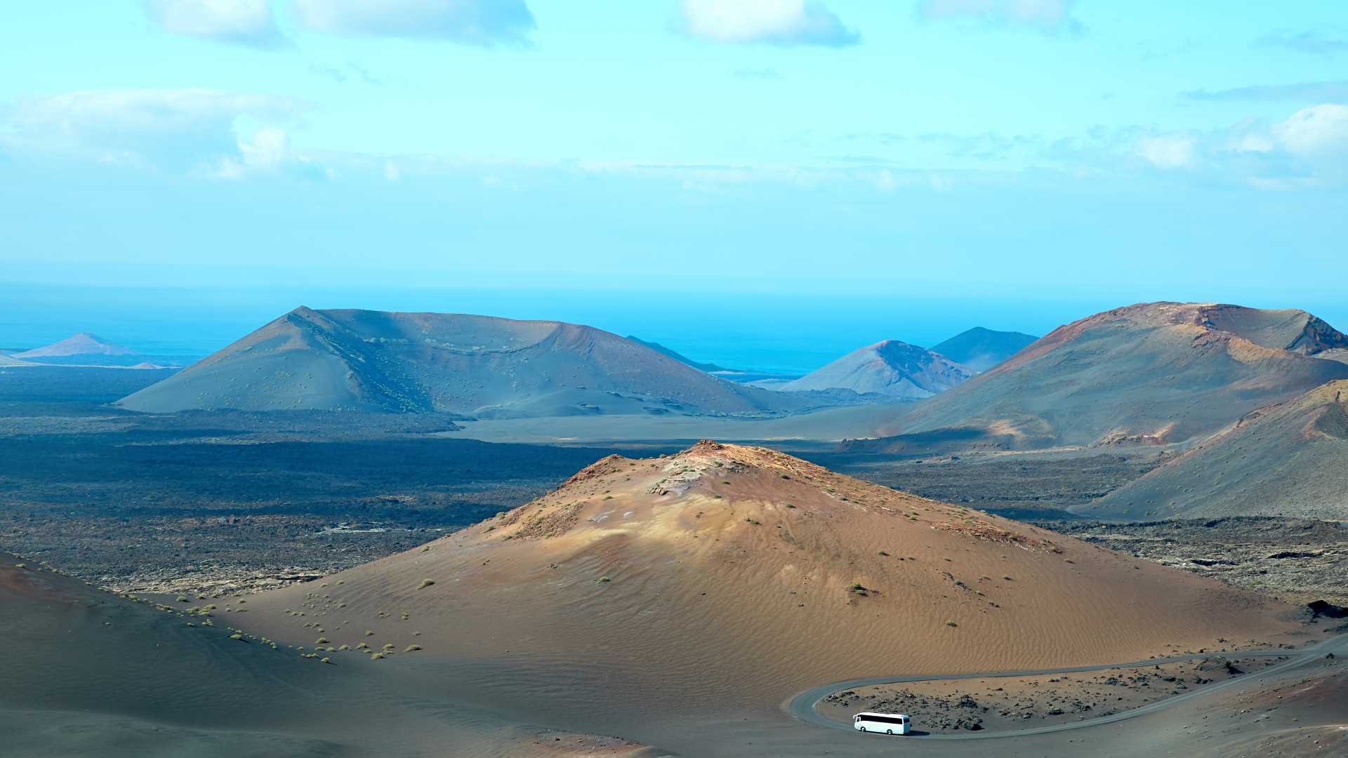 提曼法亚国家公园展示了兰萨罗特岛的火山景观和湛蓝的天空，这里是自然观光和户外活动的热门旅游目的地