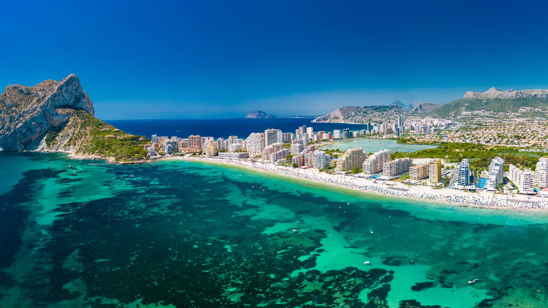 Luchtfoto van het strand van Calpe met turquoise water en de opvallende berg Penyal d'Ifach in Spanje.